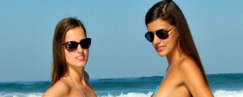 Две модельки в мини бикини на фоне моря