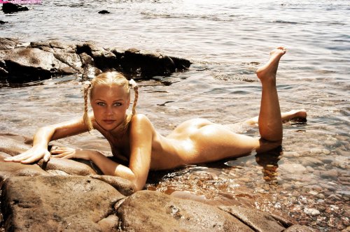 Красивая молодая гимнастка отдыхает на море