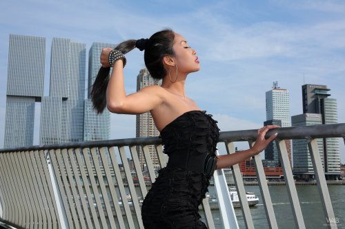 Развратная азиатка позирует голышом на фоне небоскребов